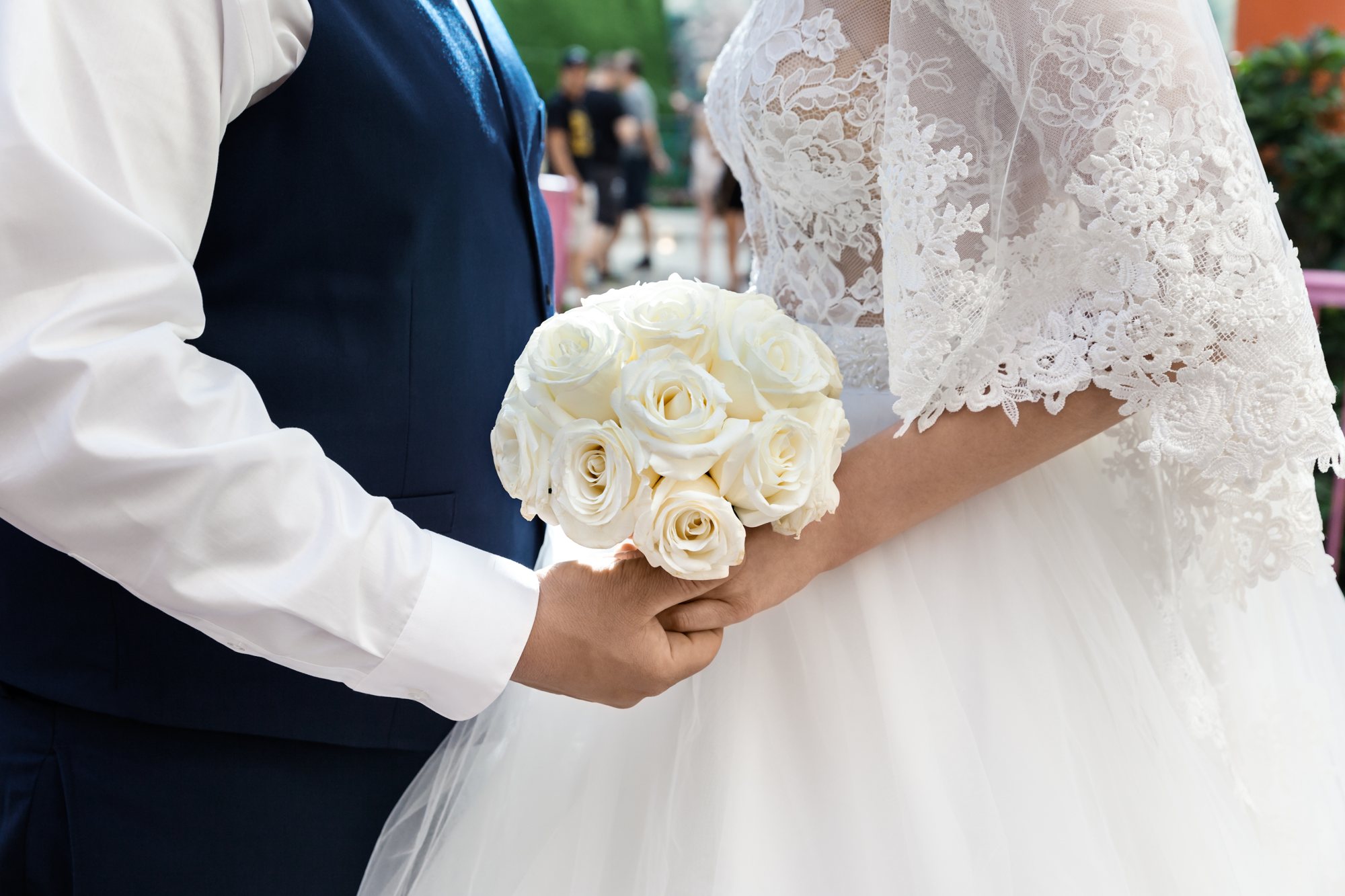 A couple holding a bouquet of white roses